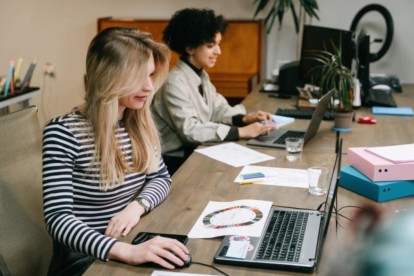 Two women collaborating at laptops, the teamwork behind the tools