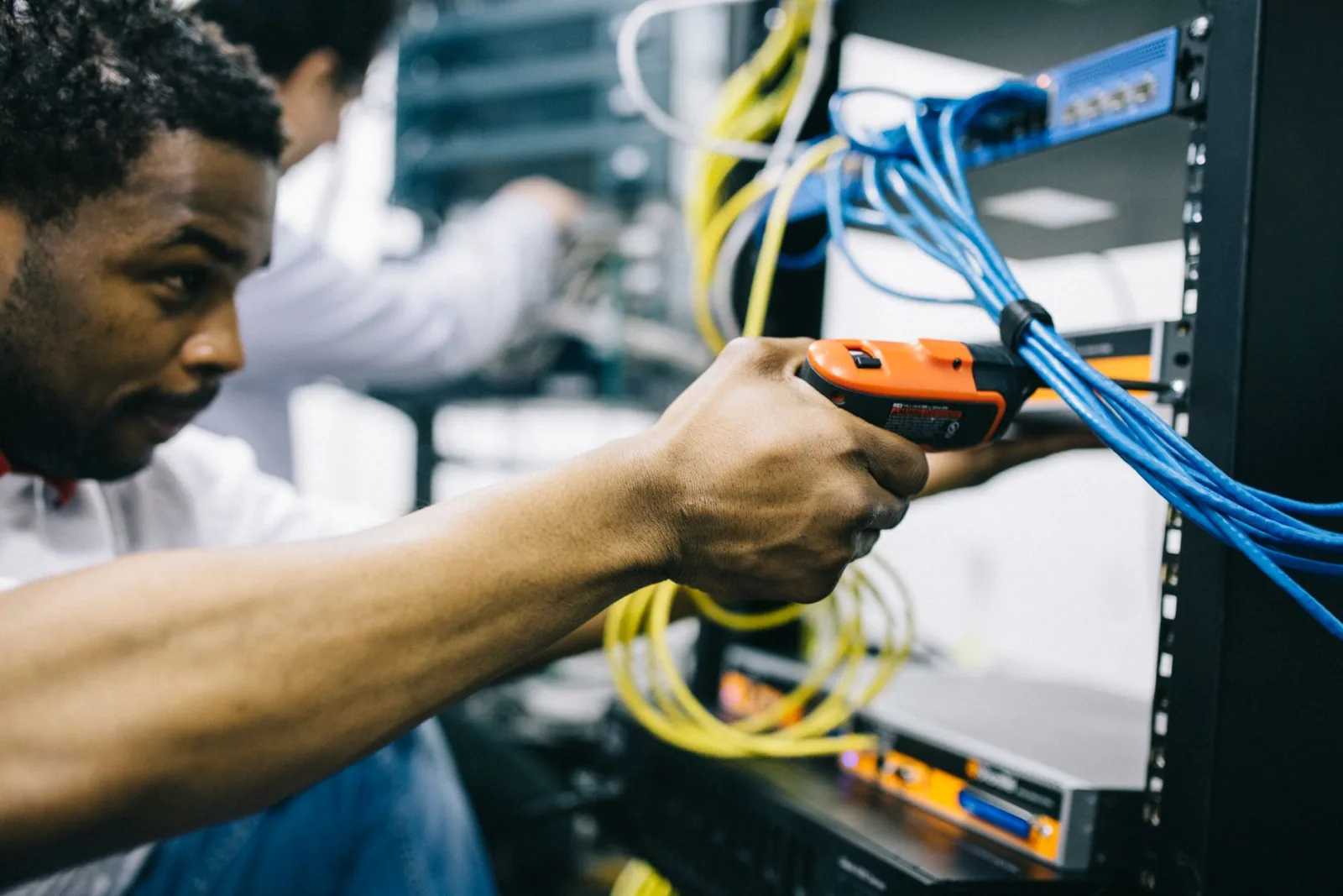 Engineer connecting network cables in a data center rack during hands-on infrastructure work