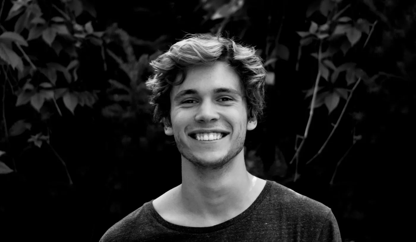 Black and white headshot with strong contrast, useful for checking whether an enhancer preserves eyes, teeth, and hair edges