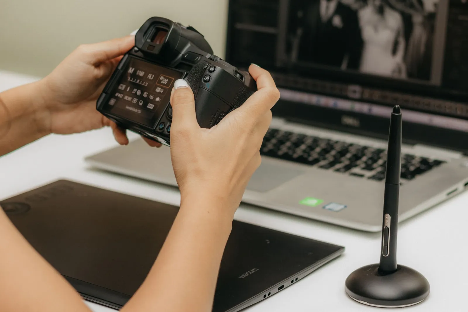 A close-up of a photographer retouching a portrait on a laptop with editing software