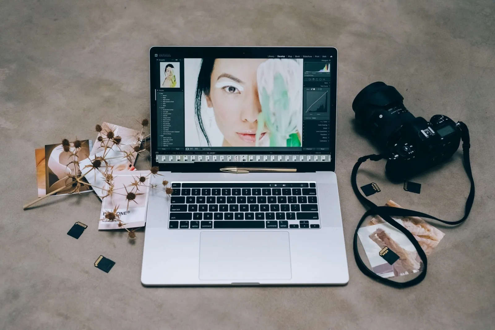 Editing desk showing AI photo enhancement software on screen with a camera nearby