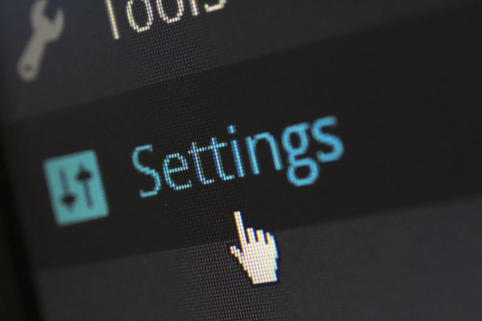 A close-up photo of a computer screen showing the settings button with a cursor hovering over it.