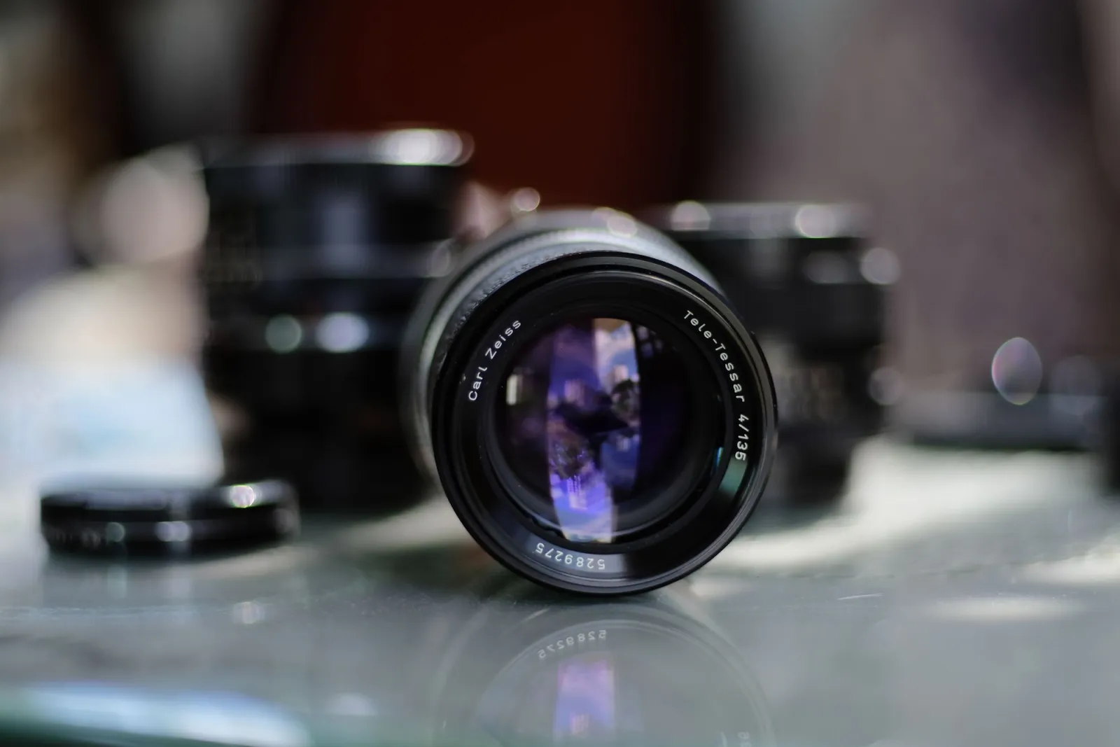 Detailed close-up of a Carl Zeiss Tele-Tessar camera lens with a blurred background, illustrating optical blur