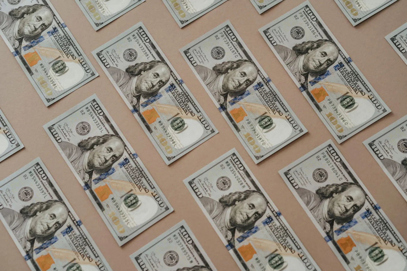 Close-up of multiple US dollar bills arranged in a grid pattern.