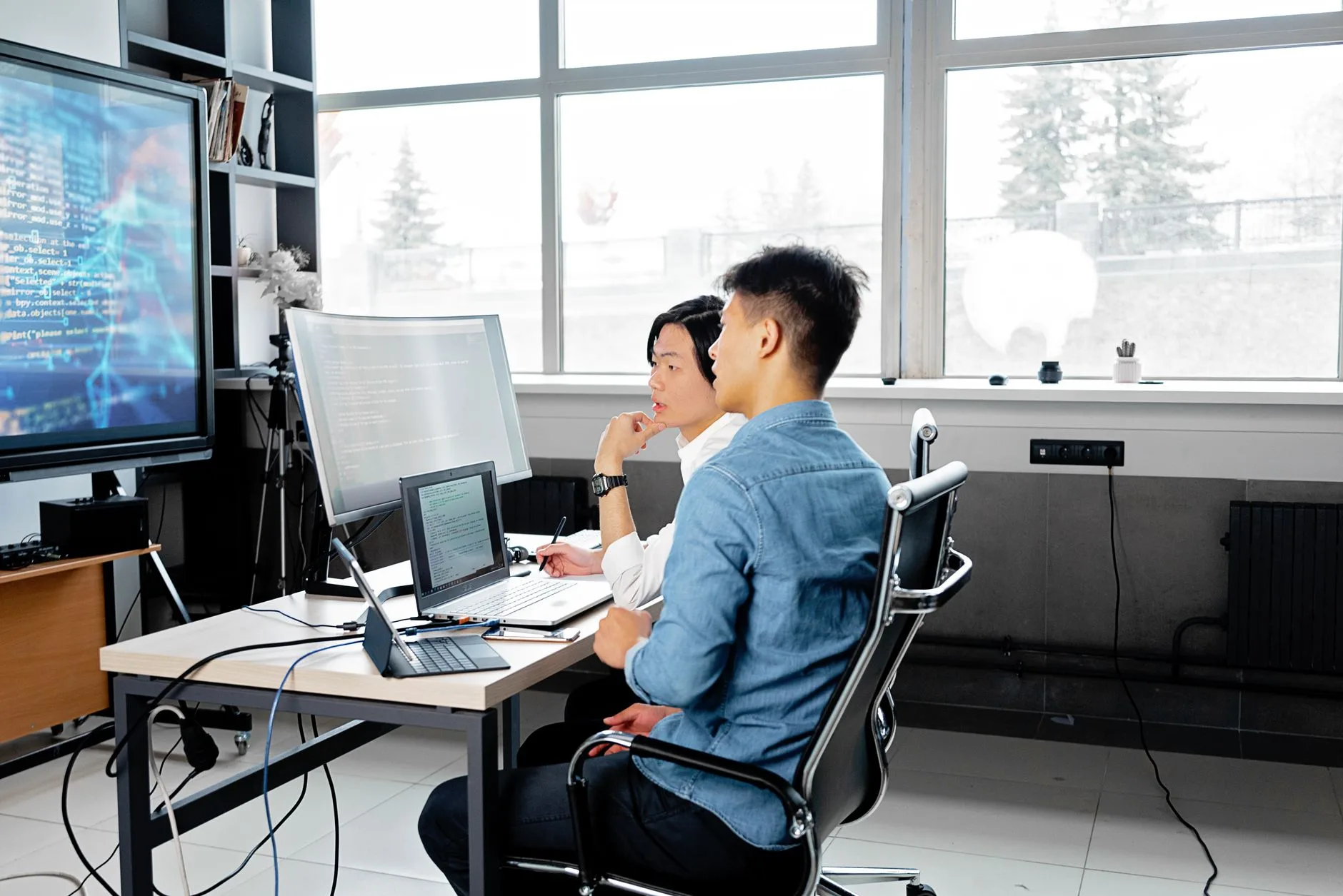 Two developers reviewing code together on screen during a pair-programming session