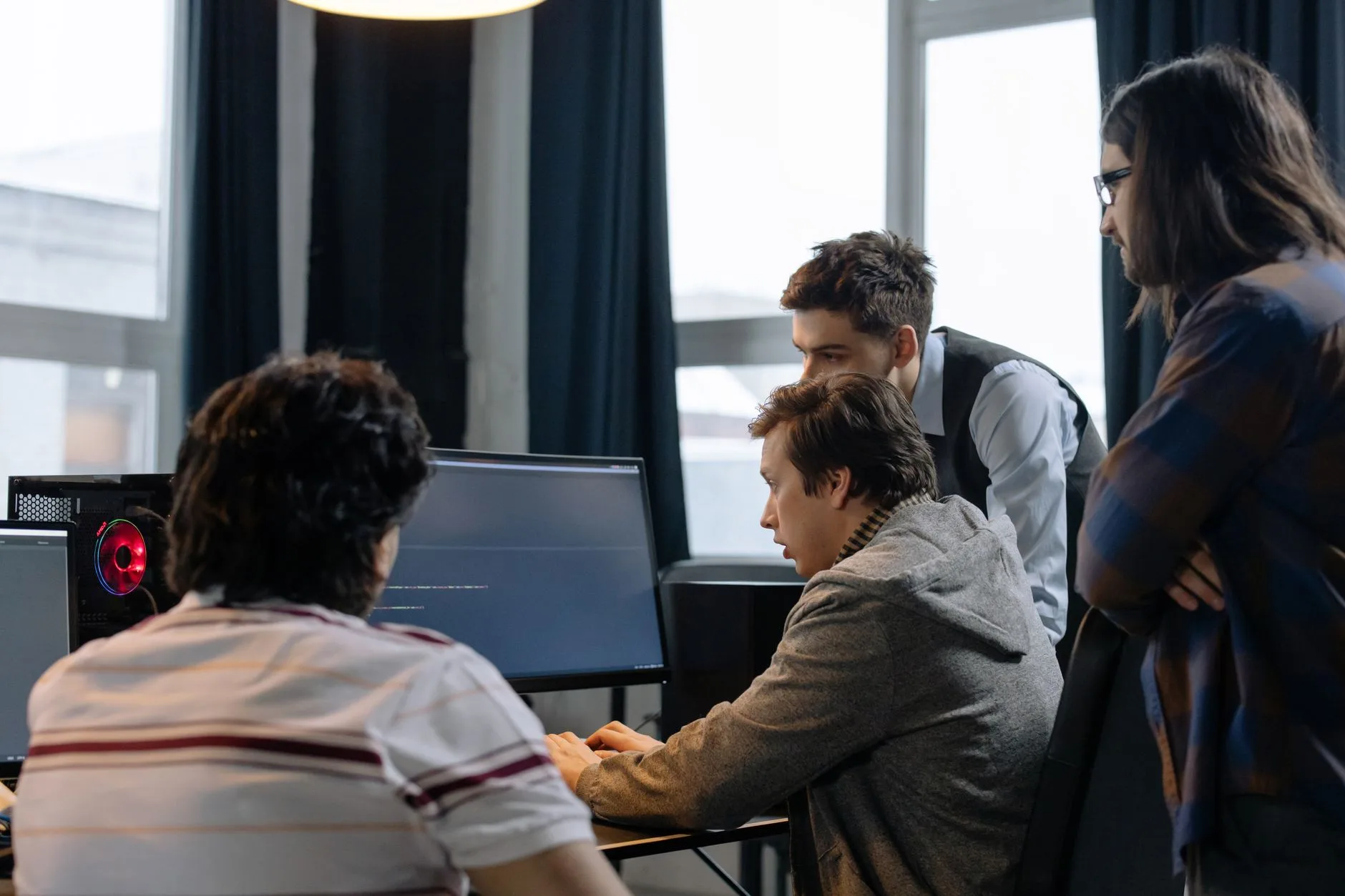 A team of software engineers collaborating around laptops in an open office