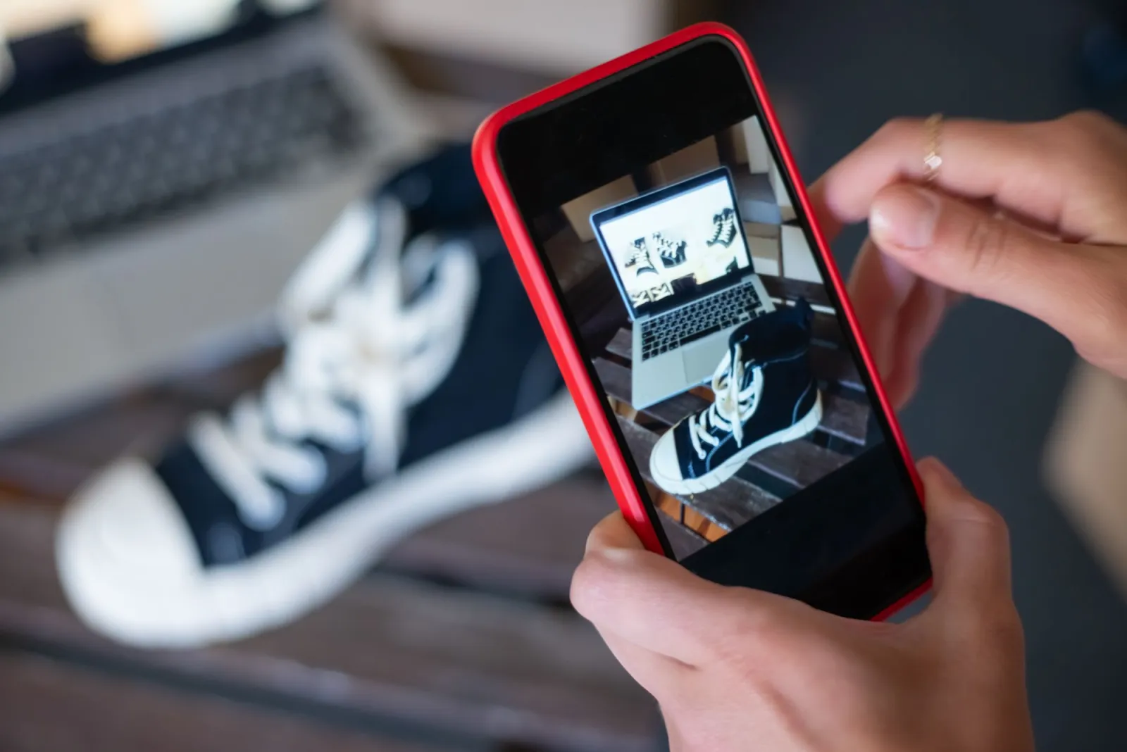 A seller photographing sneakers with a phone for an online store showcase