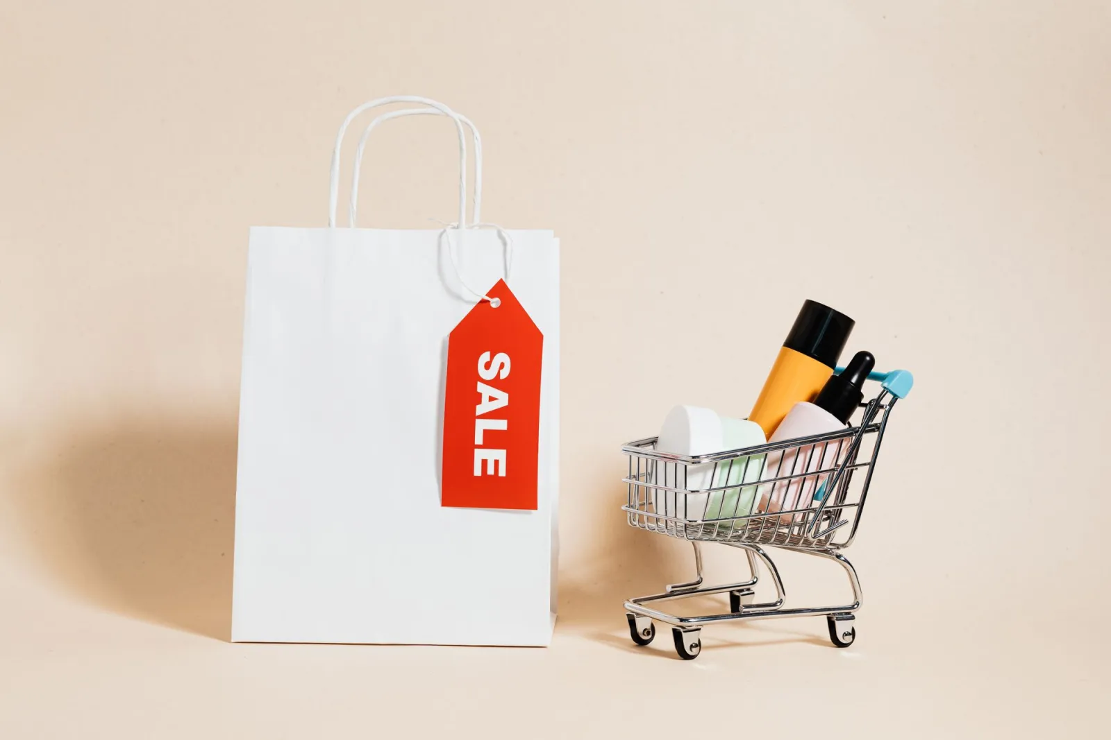 White shopping bag with a red sale tag and a mini cart for an online store
