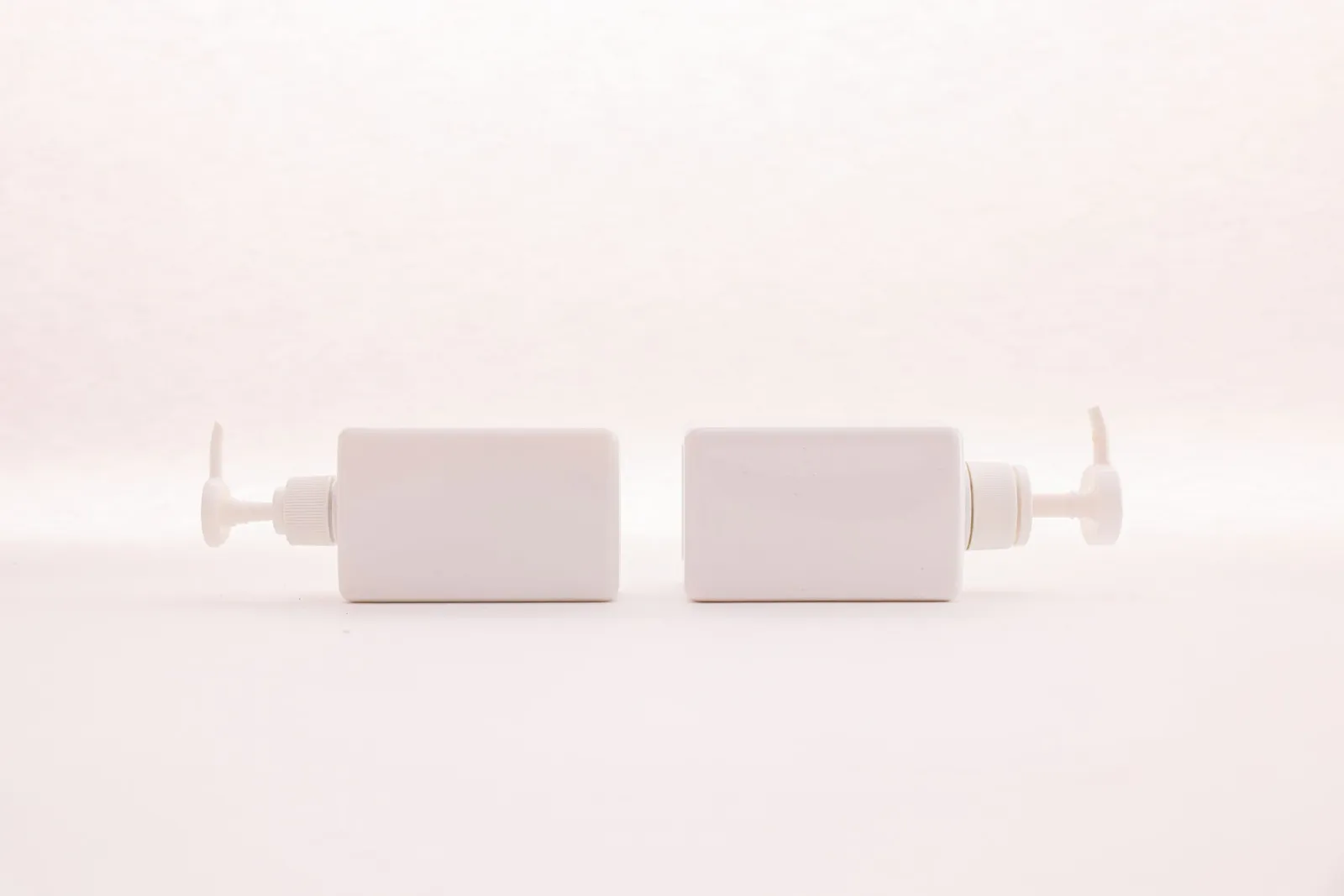 Studio product photo of white pump bottles on a pure white background