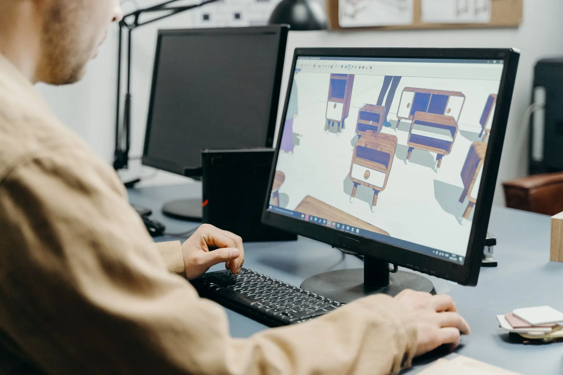 A product designer using a computer for 3D modeling in an office setting
