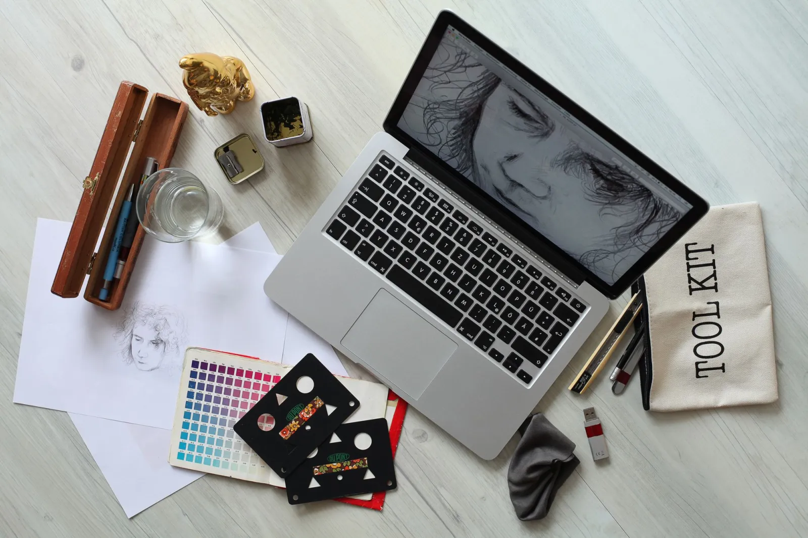 A modern desk workspace with a tablet, camera lenses, and a graphics tablet for editing