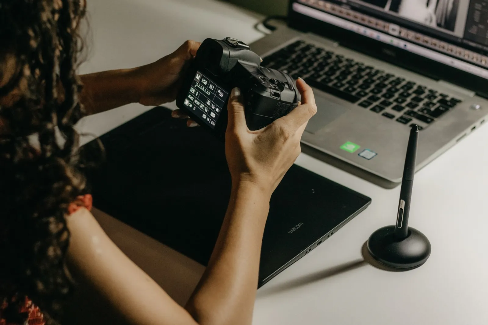 A close-up of a photographer retouching a portrait on a laptop with editing software open