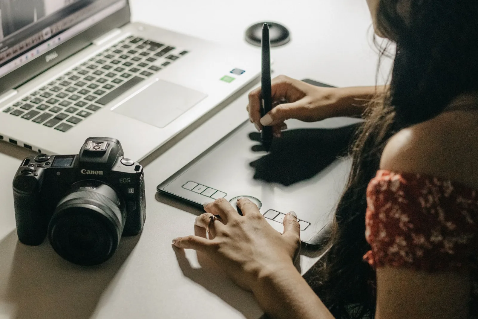 A close-up of hands on a graphics tablet, the precision input Photopea users benefit from