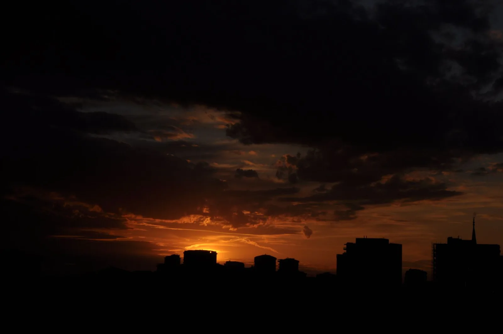 A city skyline silhouetted against a dramatic sunset, a classic HDR bracketing subject