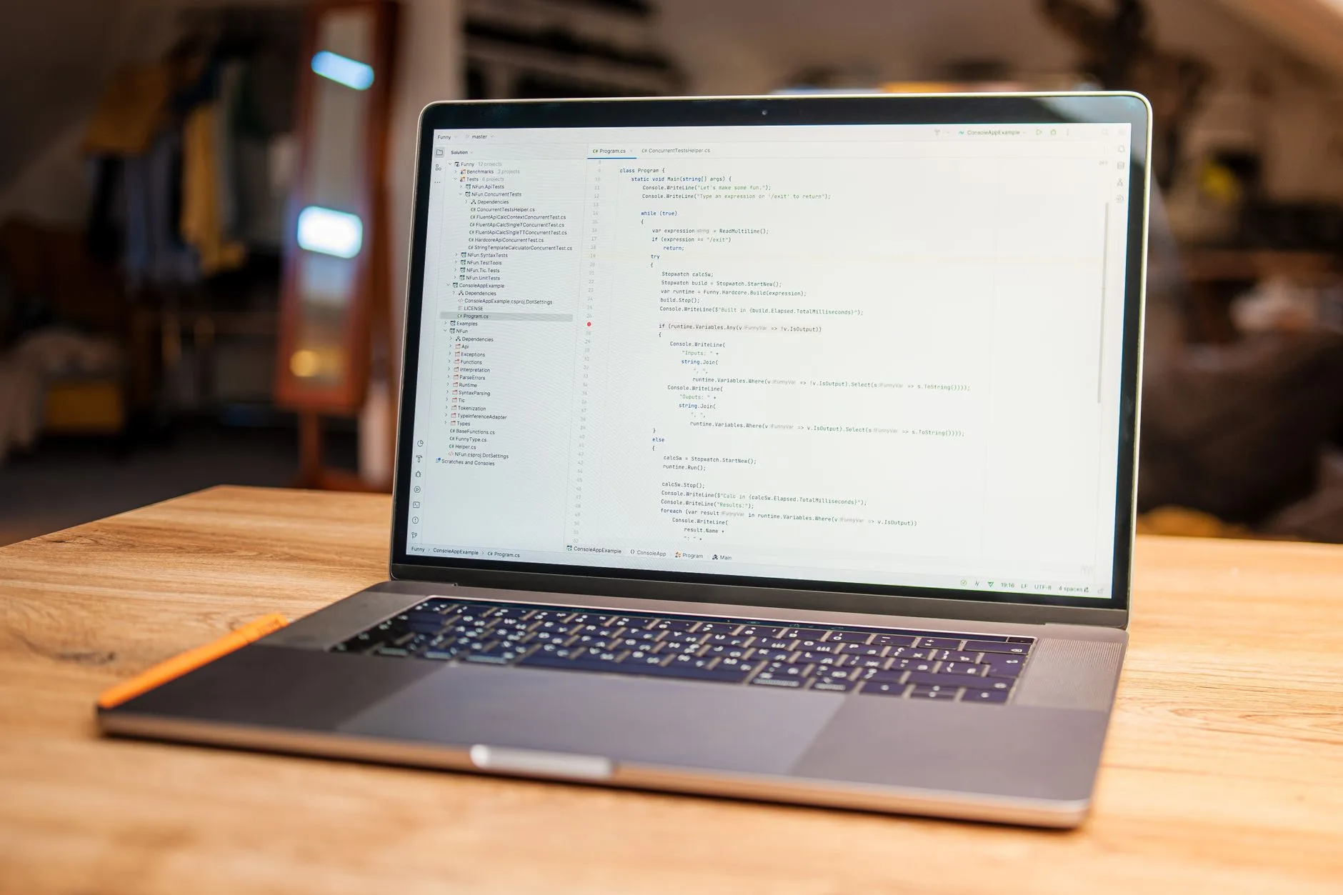 Laptop on a wooden desk showing source code open in an editor