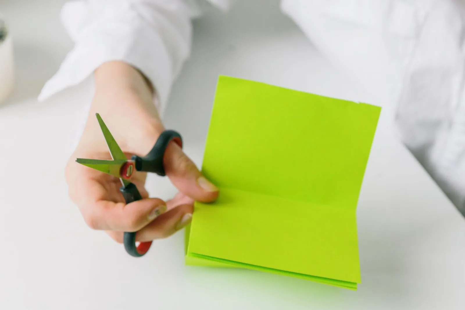 A hand holding scissors mid-cut, the moment of decision in any crop