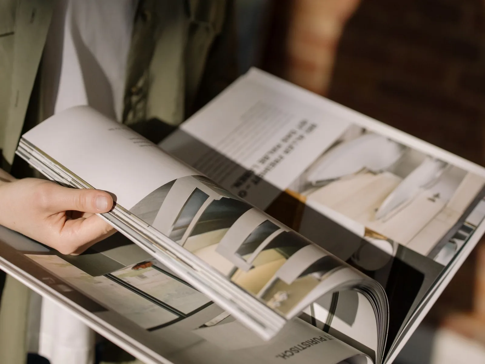 Hands turning the pages of a magazine, where print DPI determines the sharpness of the page