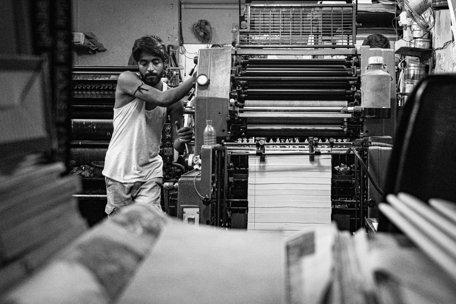 A worker operating printing equipment in a print shop, where DPI settings determine output quality