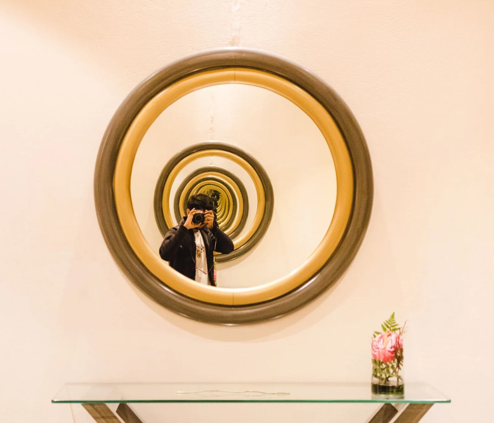 A photographer taking a picture through a mirror, where flips and reflections interact