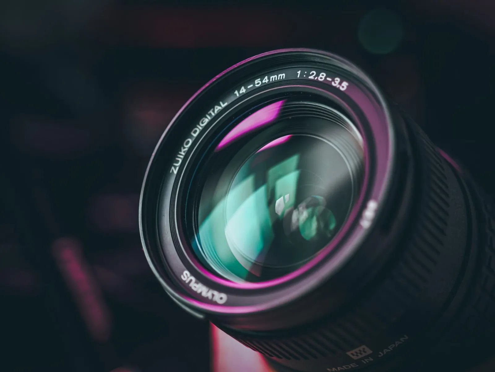 A detailed close-up shot of a camera lens with colorful reflections, showing intricate details.