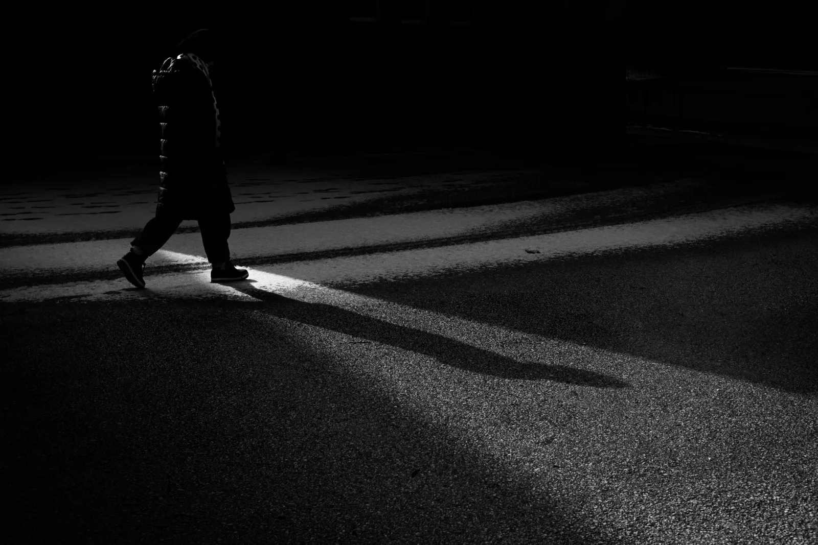 A solitary figure under dramatic light, showing directional shadow behavior