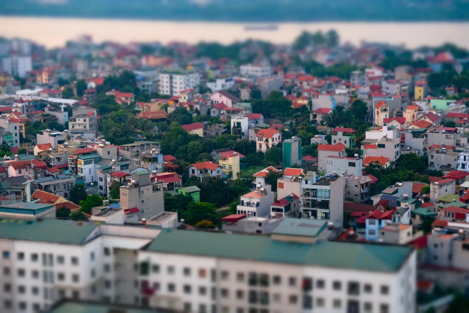 Aerial view of a cityscape with a blur effect, creating a miniature model appearance.