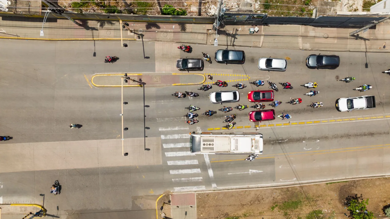 Top-down view of vehicles and motorbikes at a city intersection