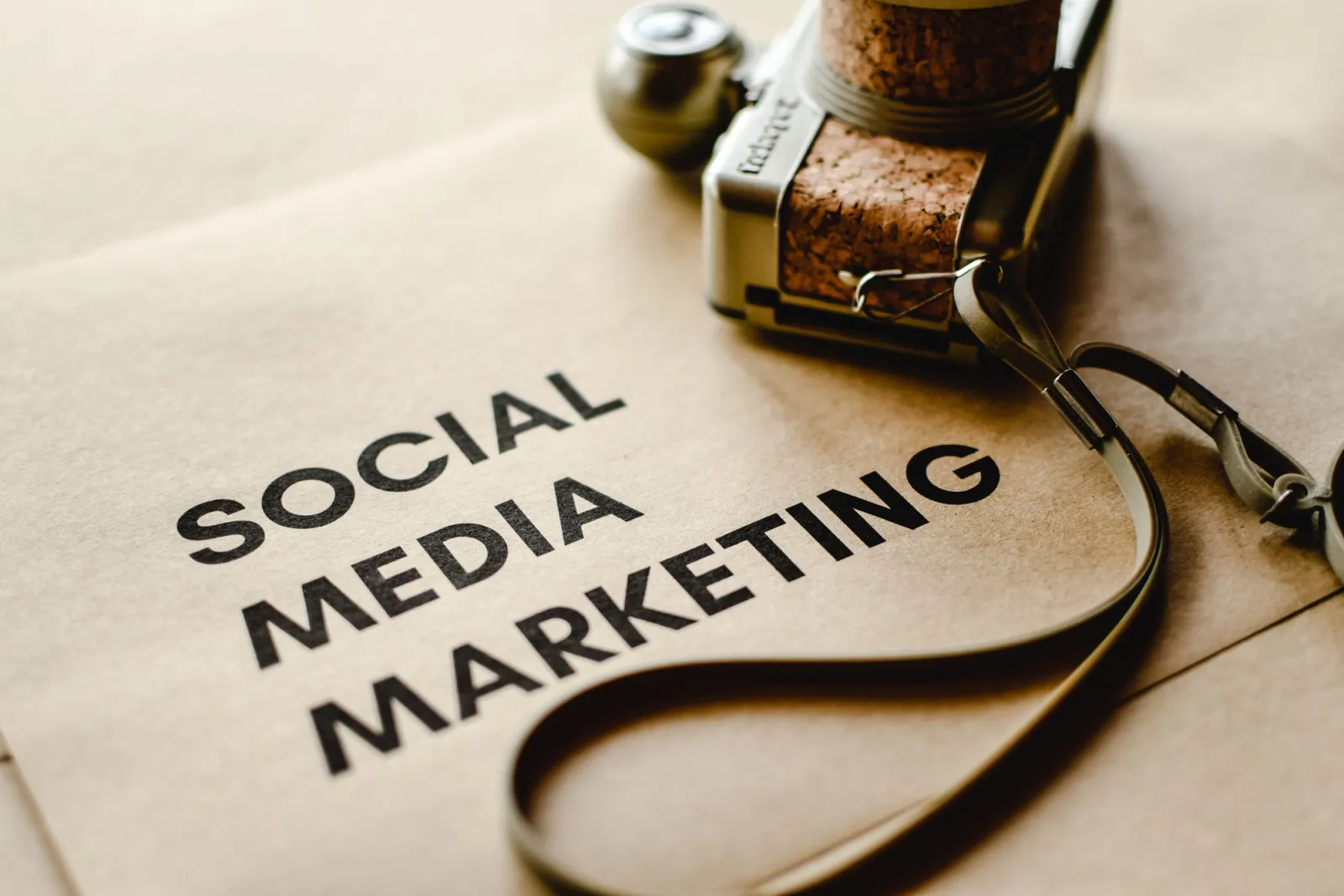 Close-up of a camera placed on brown paper with social media marketing text
