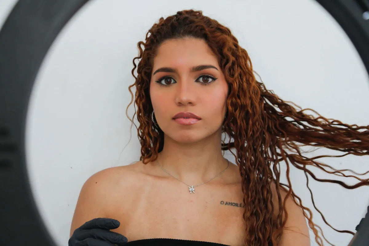 A studio portrait with backlit flying curly hair, the hardest case for automatic background removal