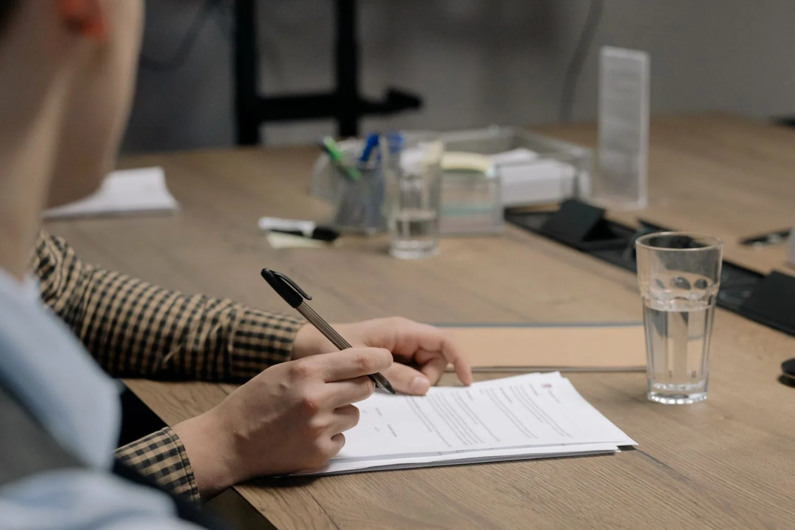 A person signing a document, the kind of ordered page that filename sequencing protects
