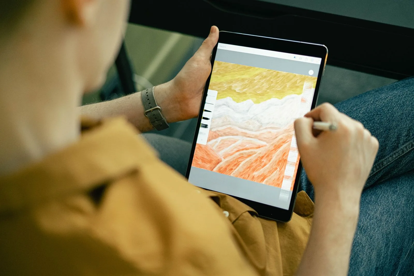 Person sketching a colorful landscape on a tablet, illustrating how a prompt becomes a draft image