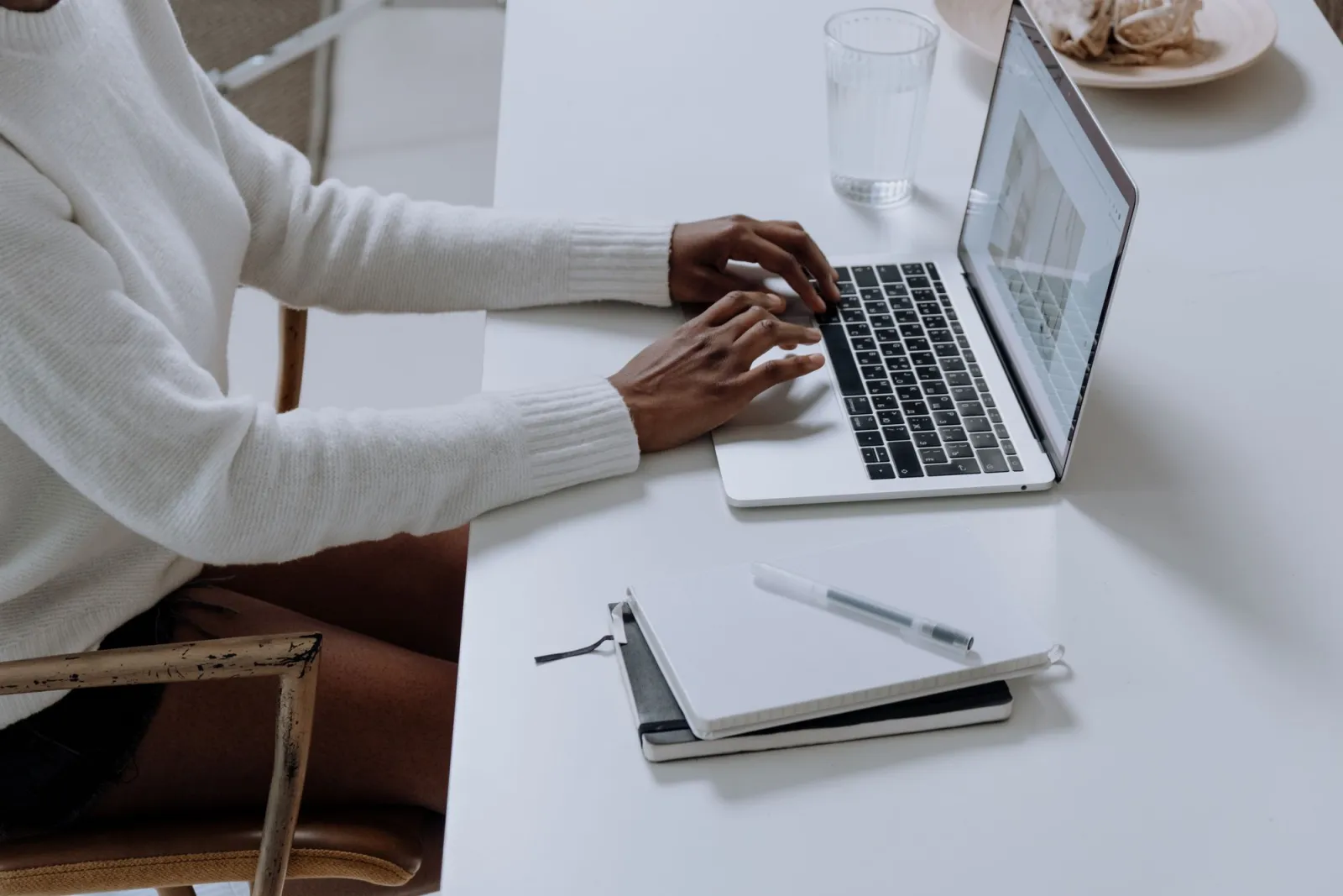 A person typing on a laptop in a minimal workspace, running a batch image job