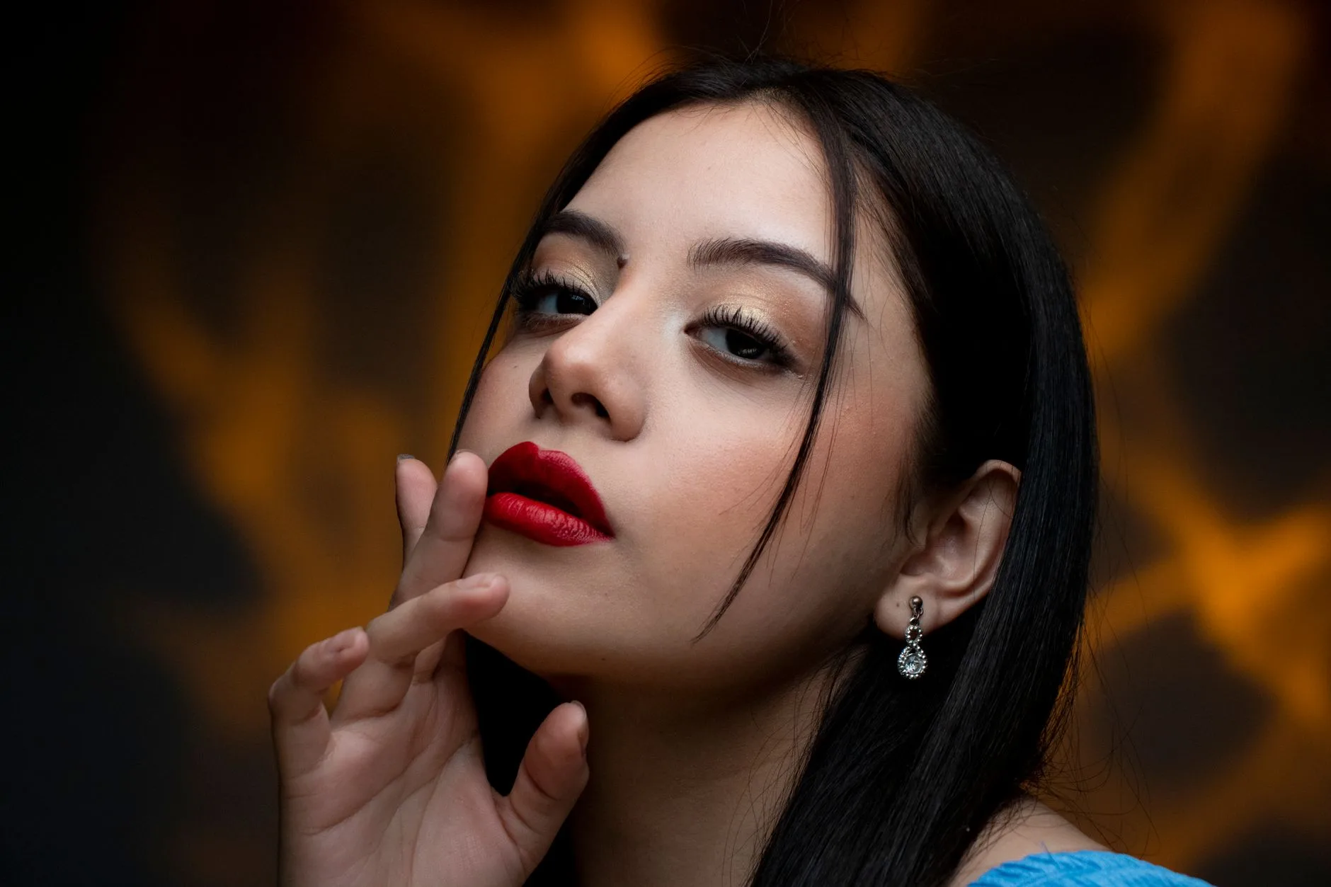 Close-up portrait of a woman with bold red lipstick and elegant earrings