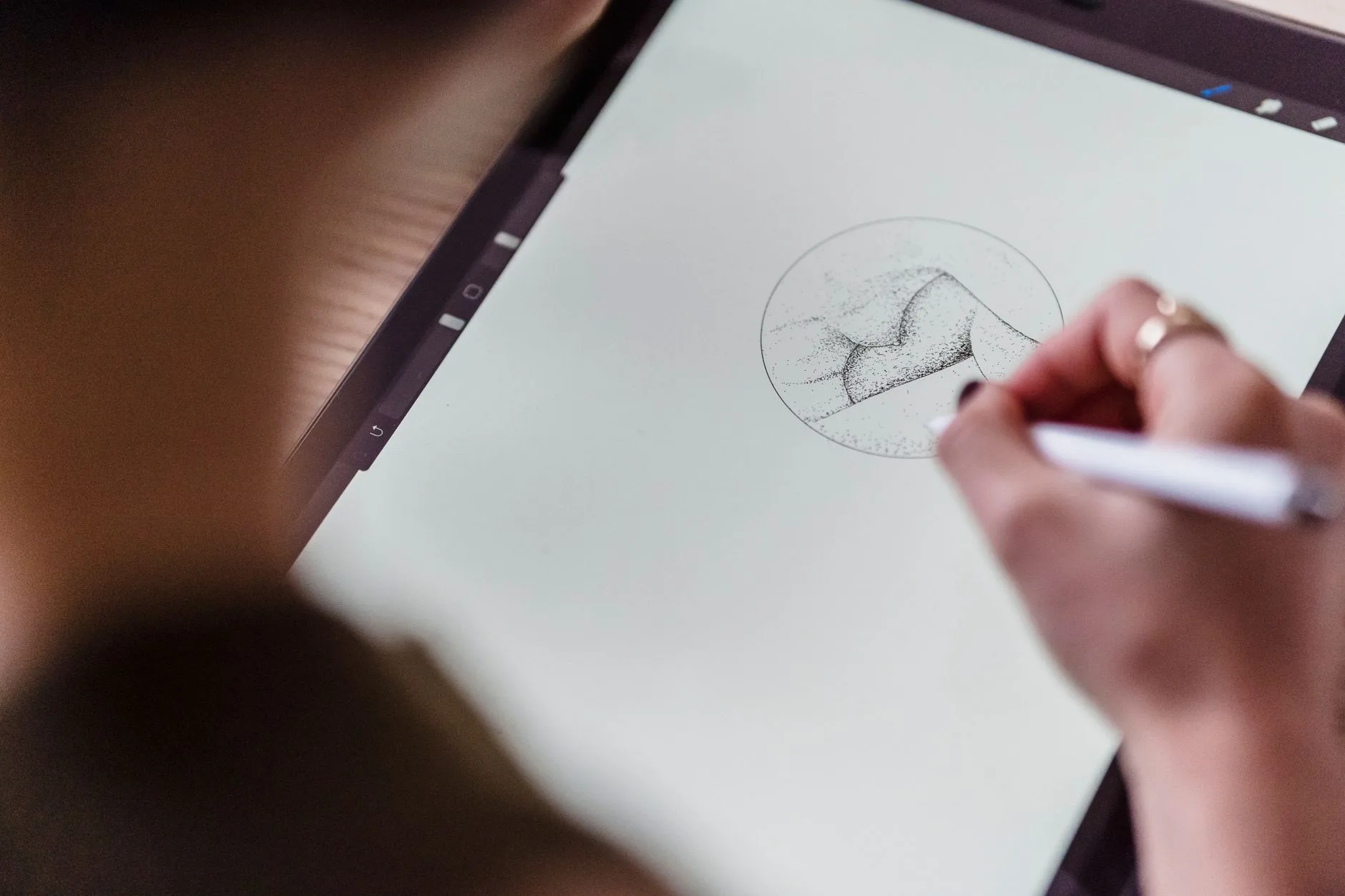 From above of an artist with stylus in hand drawing a creative sketch on a graphics tablet