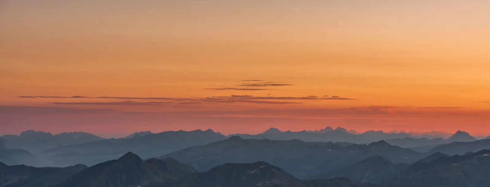 A serene mountain landscape at sunset, captured as one of several frames for a panorama