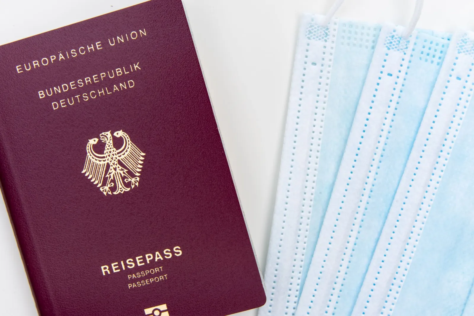 German passport and face masks concept for travel safety during pandemics.