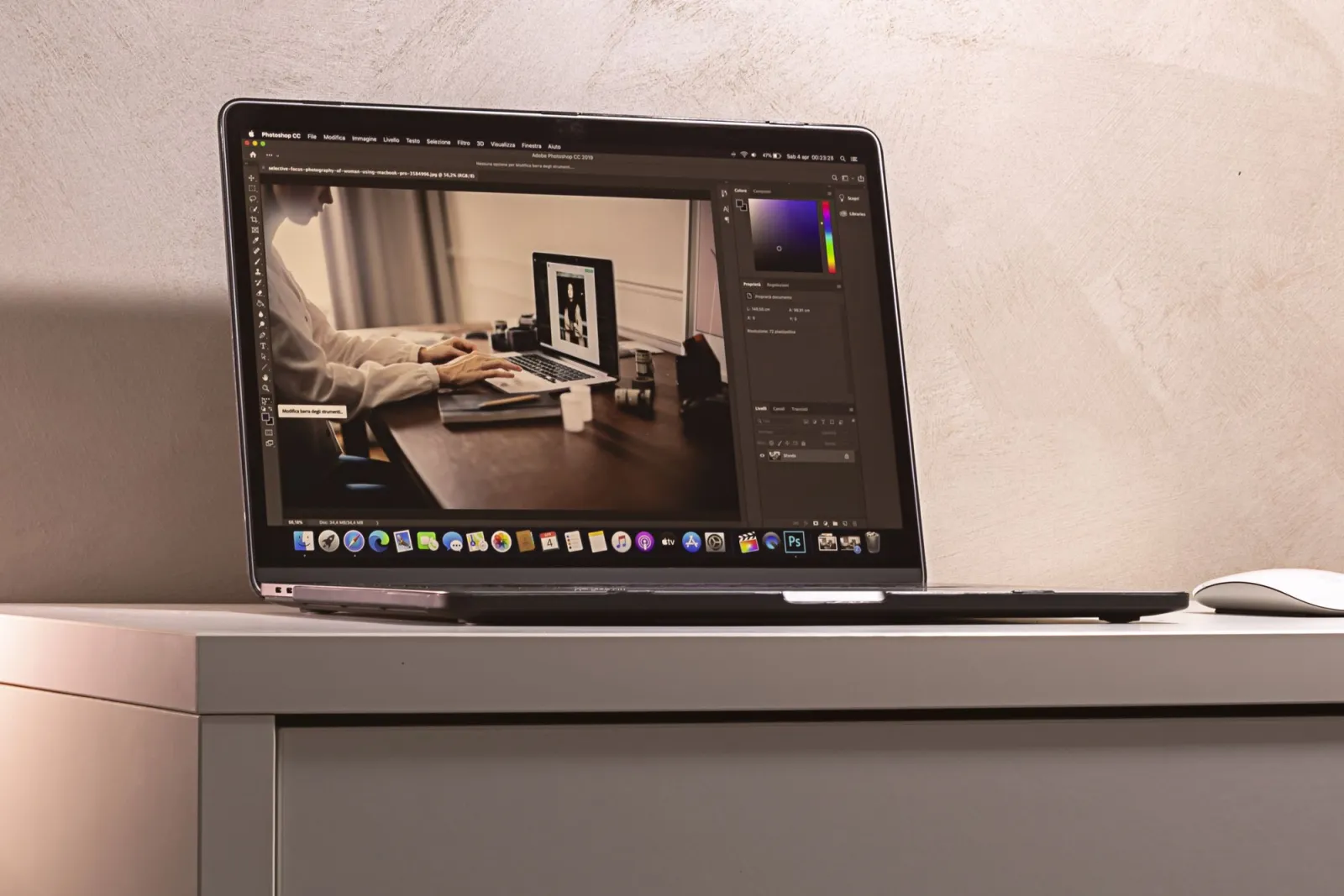 Laptop displaying photo editing software interface on a clean modern desk
