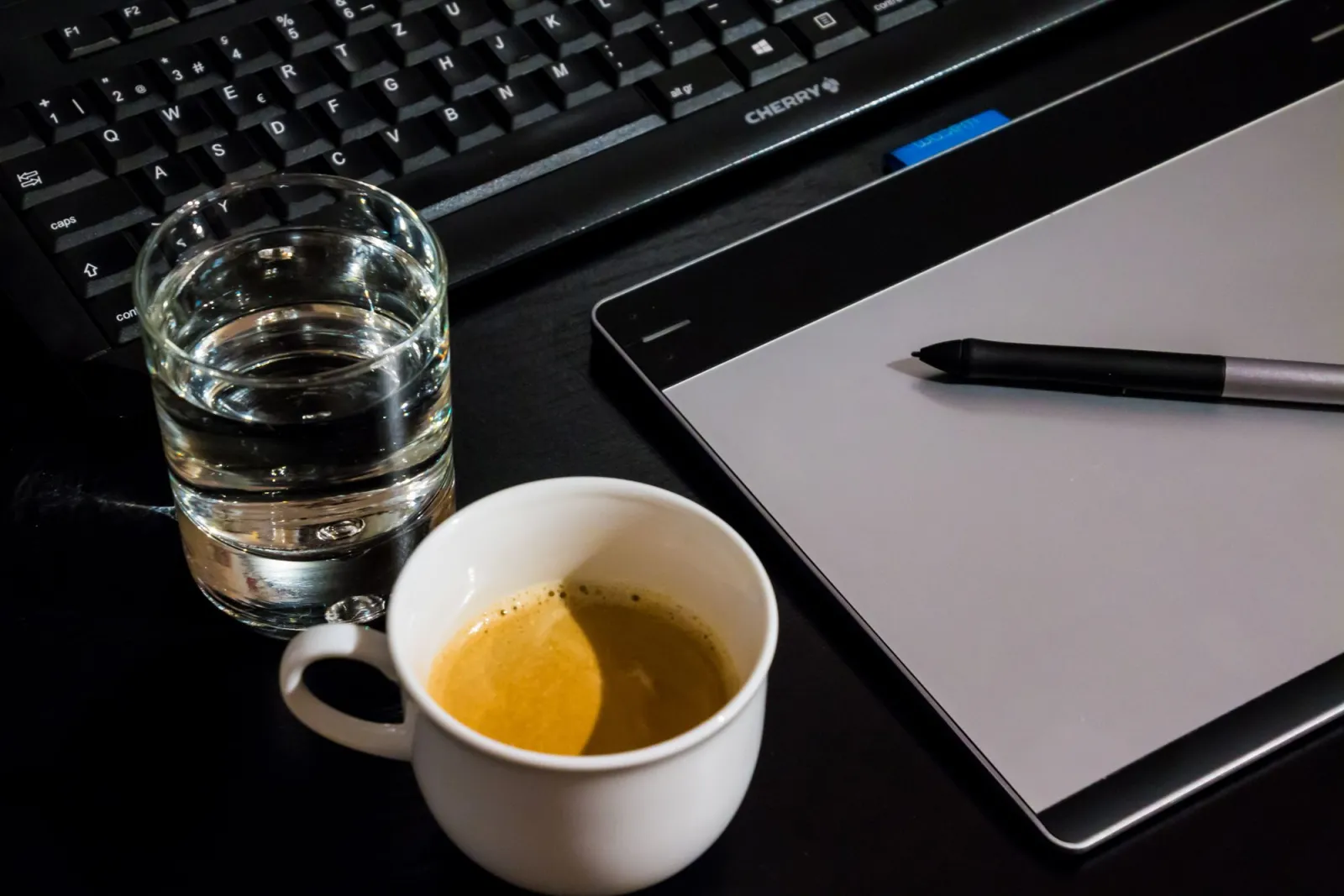 Creative editing desk setup with coffee, tablet, keyboard and notebook