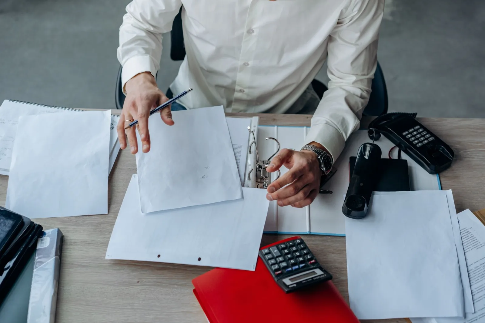 A business professional organizing documents, the final check before sending files to print
