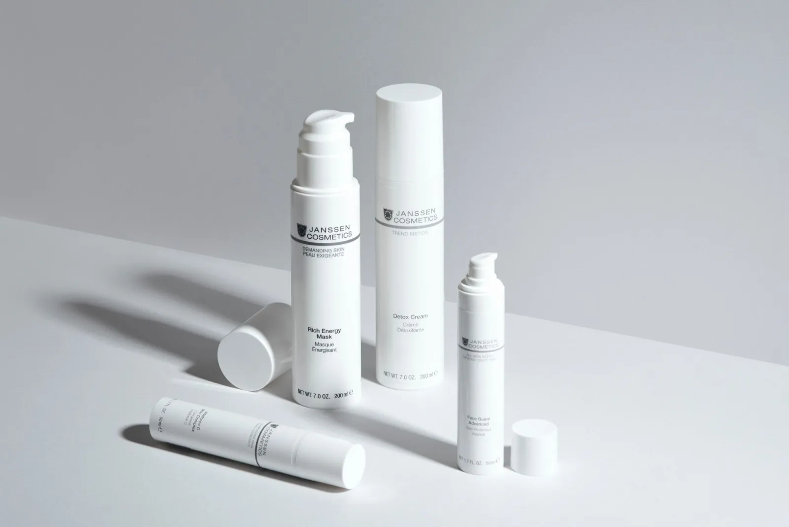 Skincare bottles on a white table showing clean minimal product styling