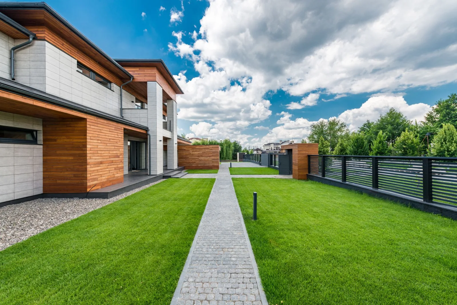 A modern residential house with a green yard, shot with corrected verticals