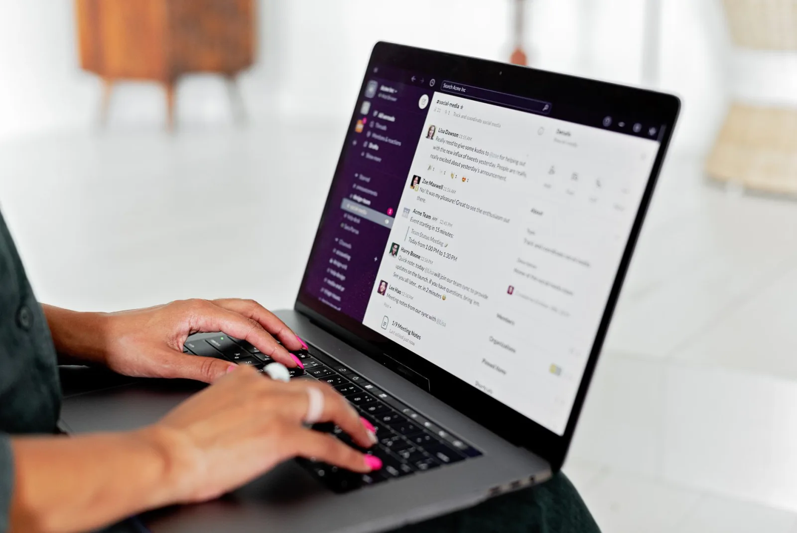 A woman typing a message on a laptop, where inline images and attachments behave differently