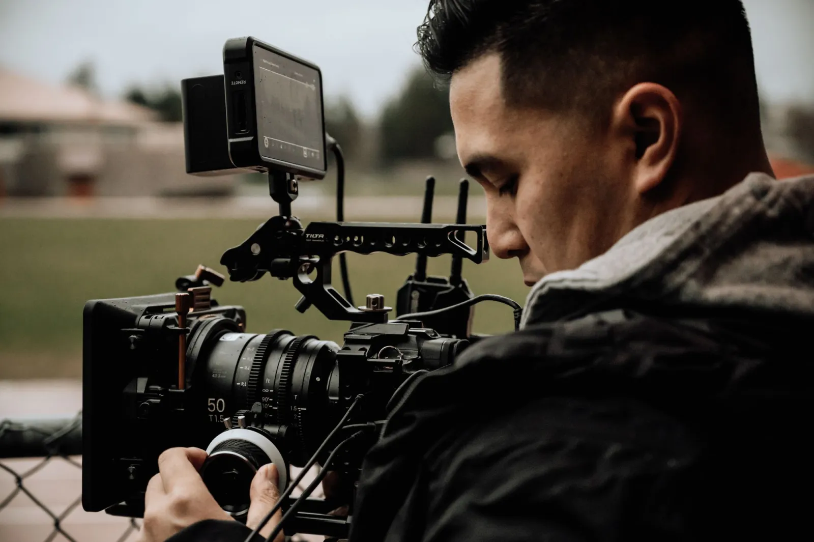 A cameraman using professional filming equipment outdoors to capture footage