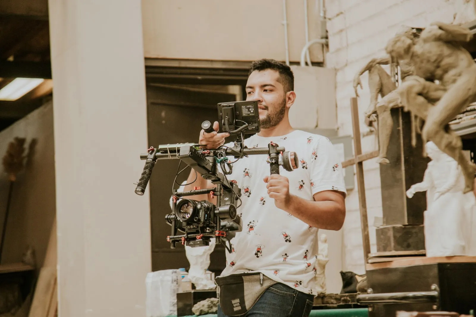 Videographer operating a professional stabilizing rig during a behind-the-scenes indoor shoot
