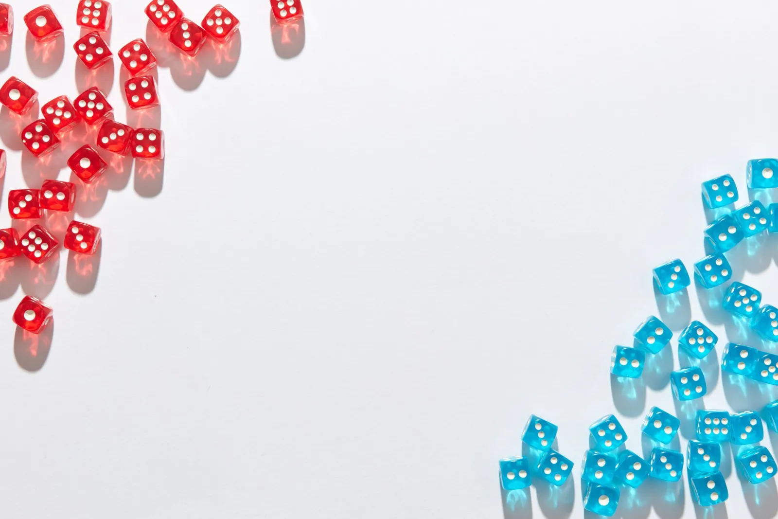 A flat lay of red and blue transparent dice on a white background, perfect for game night themes.